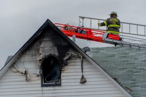 Firefighters dealing with fire and smoke damage on the rooftop 